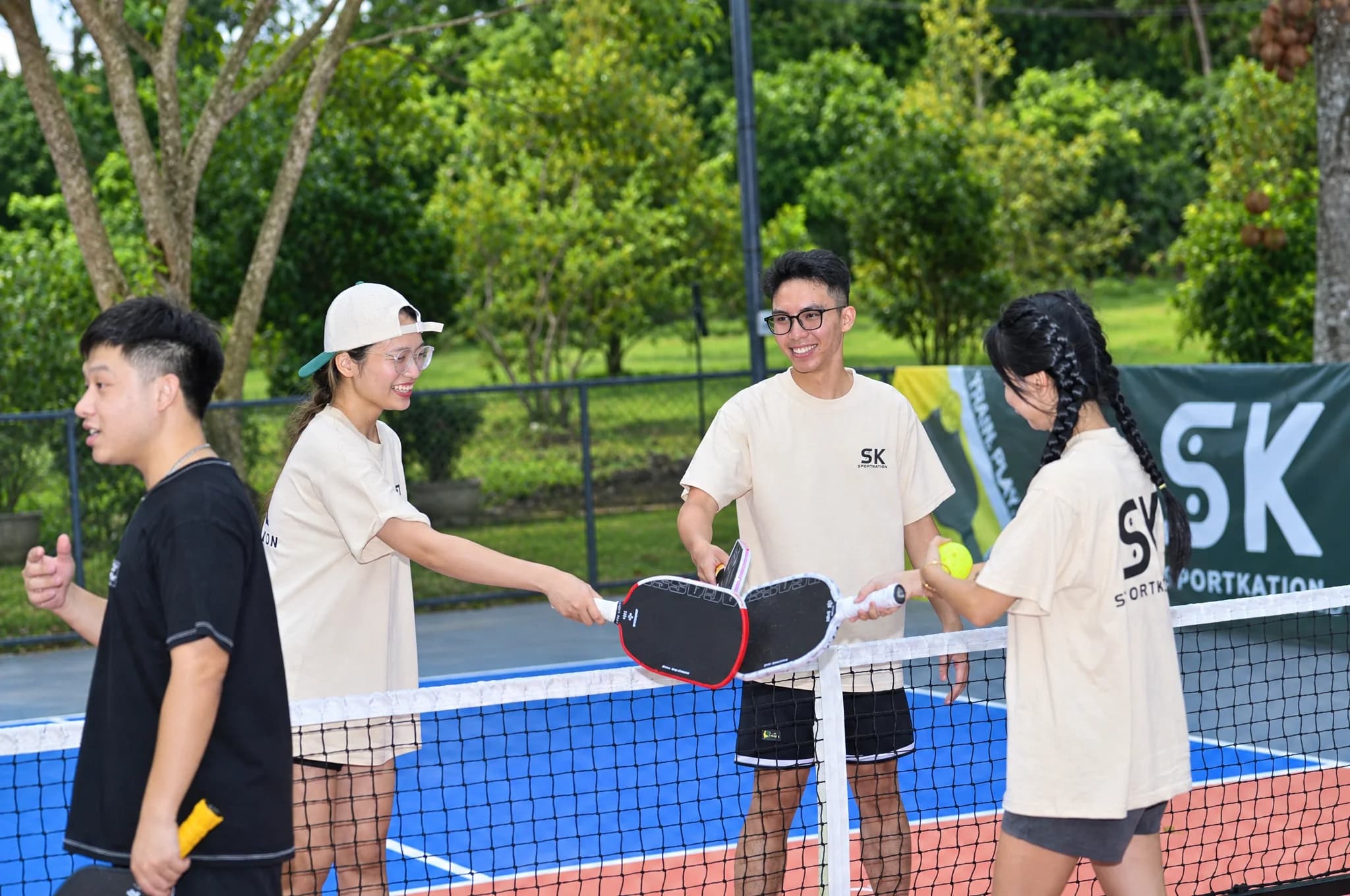 Participants greeting each other with their paddles at the net at Soojin Resort