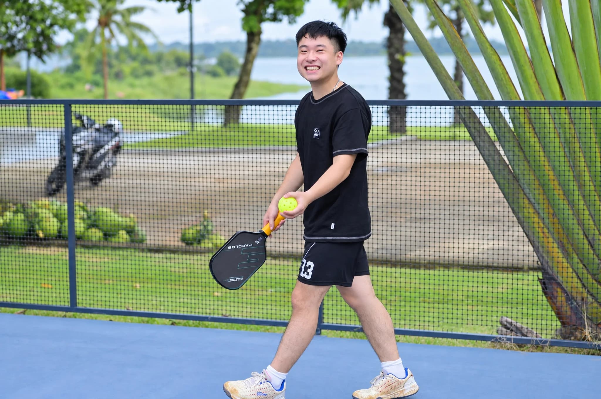 A participant holding a paddle and ball on the pickleball court at Soojin Resort
