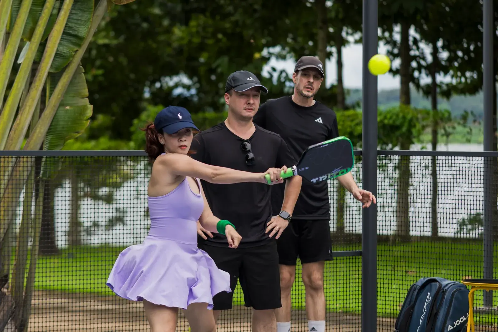 A beginner practising a pickleball shot with a coach