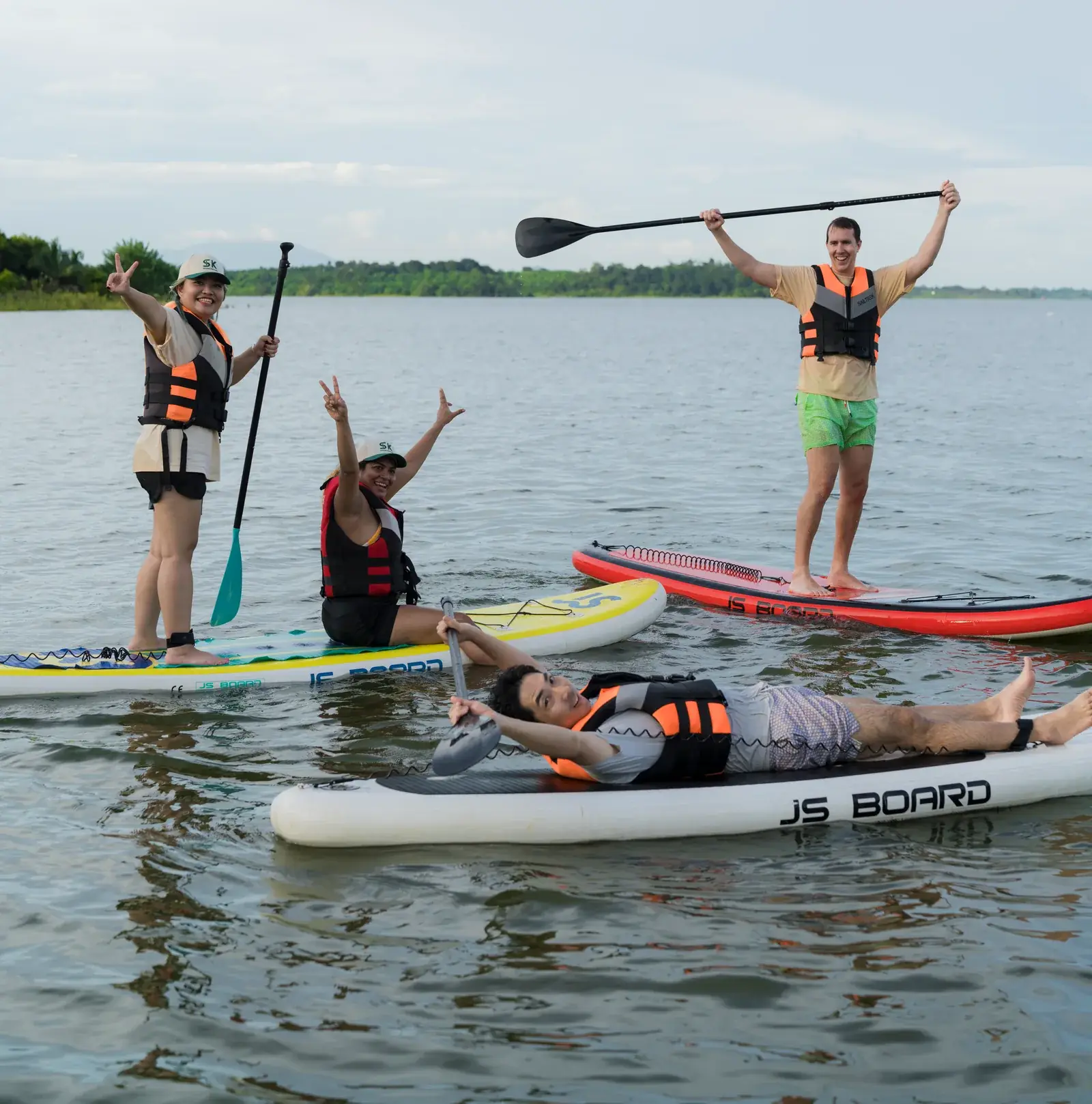 Sportkation participants wearing life jackets and enjoying paddleboarding together on the water