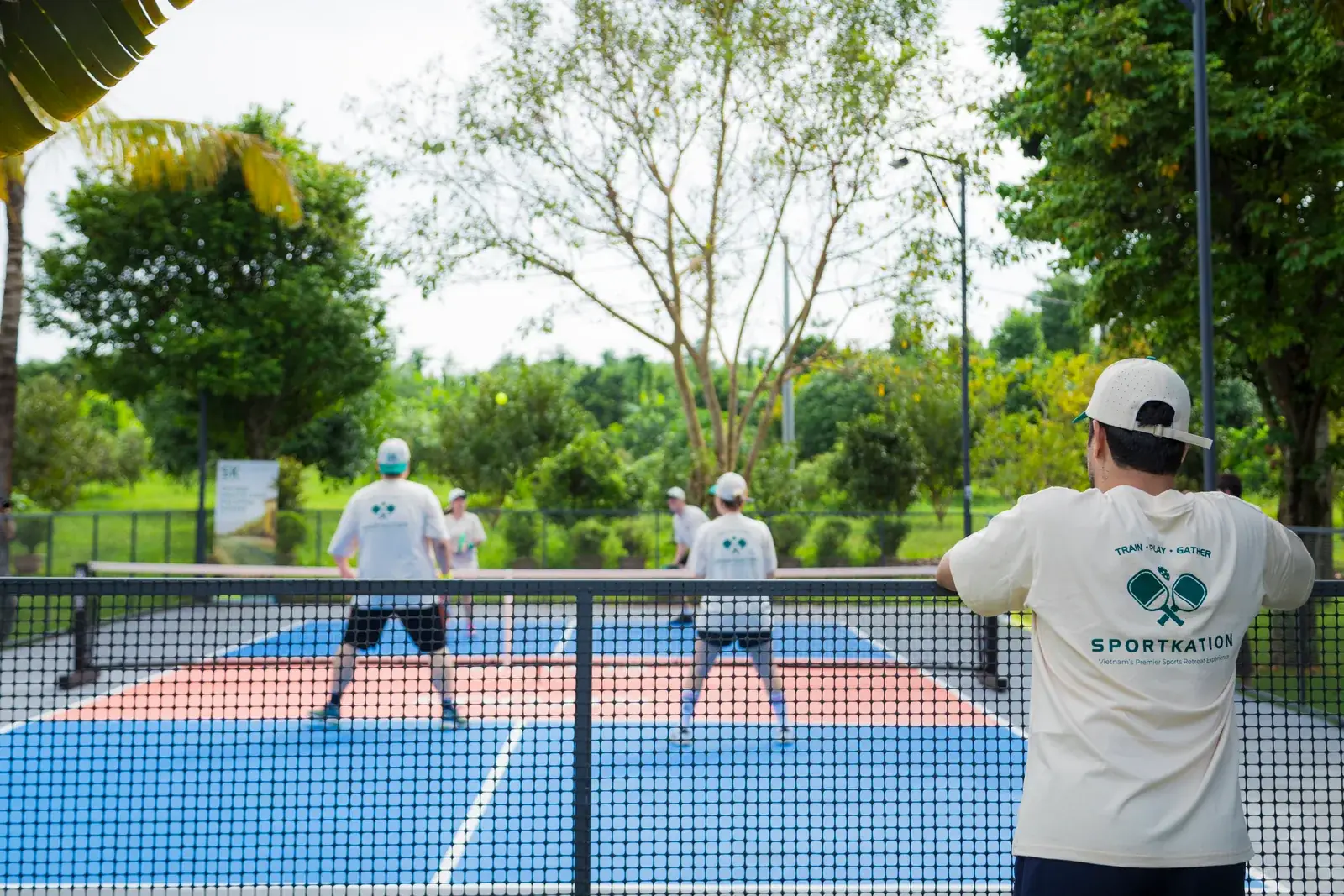 Sportkation participants playing doubles on the tree-lined pickleball courts at Soojin Resort