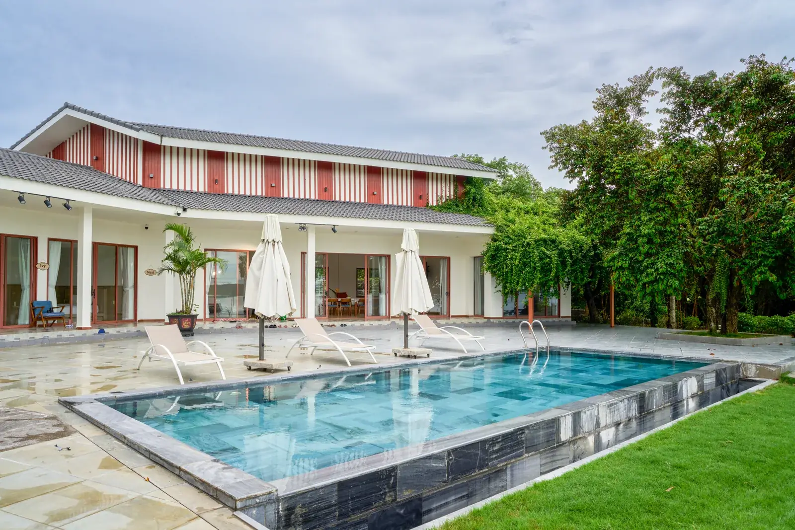 The pool and accommodation at Soojin Resort in a tropical garden
